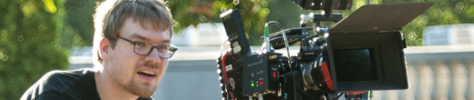 Young man using a large camera to film