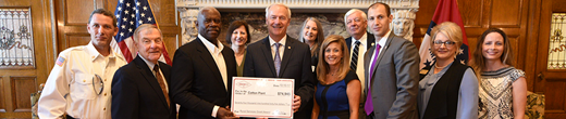 Group of people with the governor receiving a large check